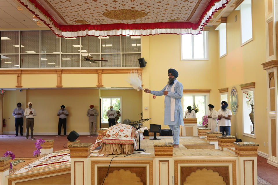 Raghuvinder Singh, center, participates in a Sikh worship service at a gurdwara in Glen Rock, N.J., Sunday, Aug. 15, 2021. Baba Punjab Singh, a Sikh priest visiting from India, was shot in the head by a white supremacist Army veteran in Wisconsin in 2012, and left partially paralyzed. He died from his wounds in 2020. Over seven years, the priest’s son, Raghuvinder Singh, split his time between caring for his father in Oak Creek and working in Glen Rock, New Jersey, as assistant priest at a gurdwara there. Raghuvinder said the greatest lesson his father taught him was how to embody “chardi kala,” which calls for steadfast optimism in the face of oppression. (AP Photo/Seth Wenig)