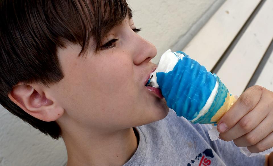 Jefferson Middle School eighth-grader Drew Matzinger, 12, enjoys his teal (blue raspberry) dip frozen custard cone at Lucy's Frozen Custard on Teal Tuesday.