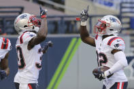 New England Patriots free safety Devin McCourty, right, is greeted by his twin brother, cornerback Jason McCourty, left, after Devin McCourty intercepted a pass for a touchdown during the first half of an NFL football game against the Seattle Seahawks, Sunday, Sept. 20, 2020, in Seattle. (AP Photo/John Froschauer)