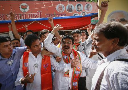Supporters of Bharatiya Janata Party (BJP) celebrate after learning of initial poll results outside their party office in outside their party office in Mumbai October 19, 2014. REUTERS/Danish Siddiqui