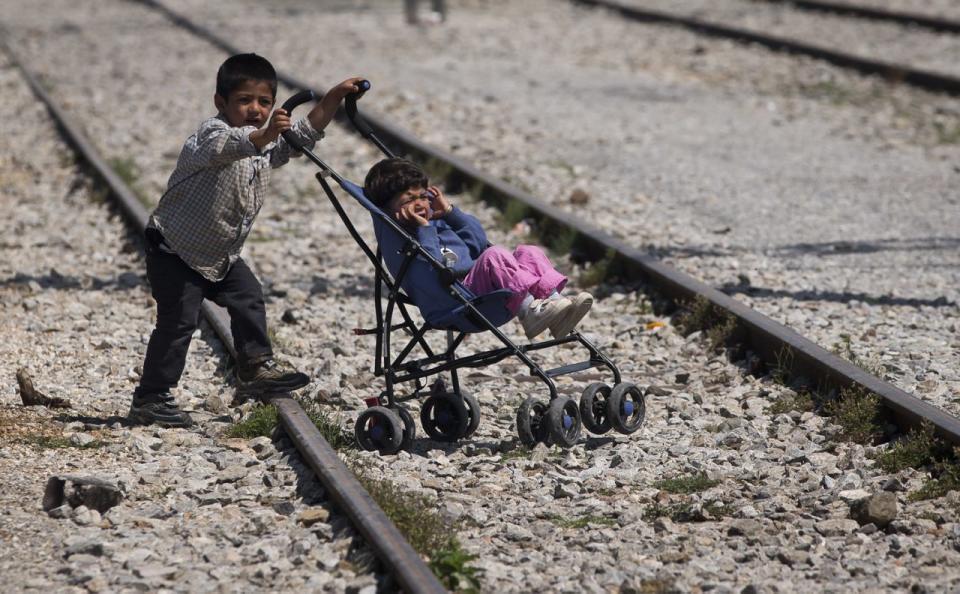 Ein Junge schiebt ein kleineres Kind in einem Buggy im Flüchtlingscamp in Idomeni. (Bild: Darko Bandic/ AP)