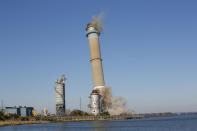 The smokestack at the former B.L. England Generating Station, a coal and oil burning power plant in Upper Township, N.J., is toppled during a control demolition on Thursday, October 26, 2023. The site will be redeveloped as a mixed-use residential and commercial project, and a nearby electrical substation will be used to connect New Jersey's soon-to-come offshore wind farms with the electrical grid. (AP Photo/Ted Shaffrey)