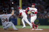 Los Angeles Angels second baseman David Fletcher, right, turns a double play over the slide by Detroit Tigers' Jake Rogers during the fifth inning of a baseball game in Anaheim, Calif., Saturday, June 19, 2021. Harold Castro was out at first. (AP Photo/Kyusung Gong)