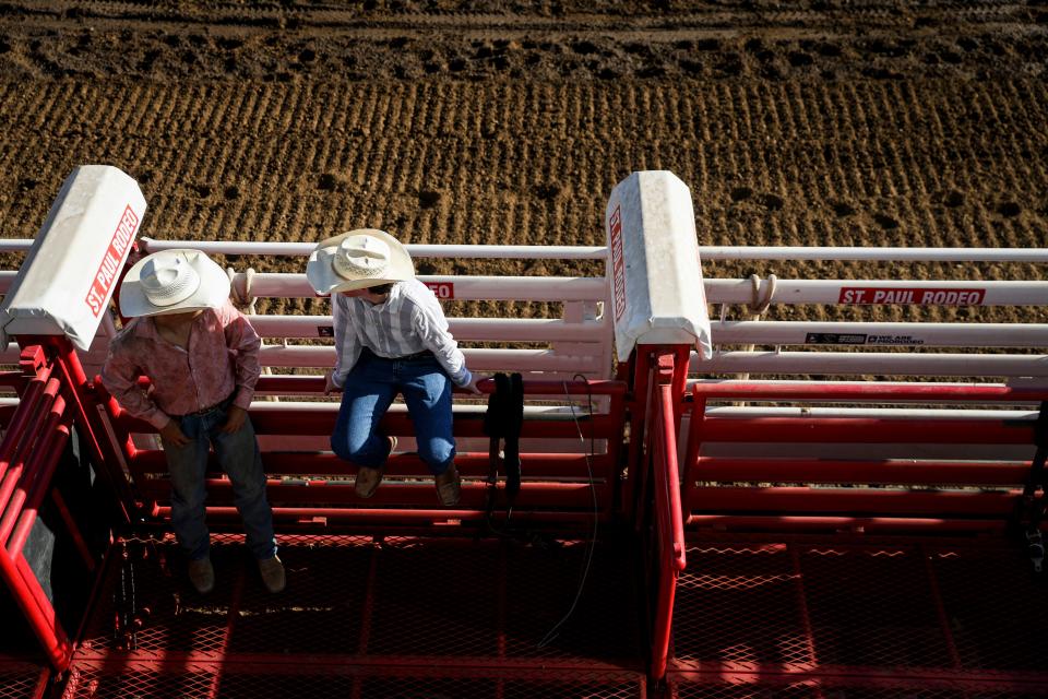 Cowboys hang out behind the chutes Friday before the start of the St. Paul Rodeo.