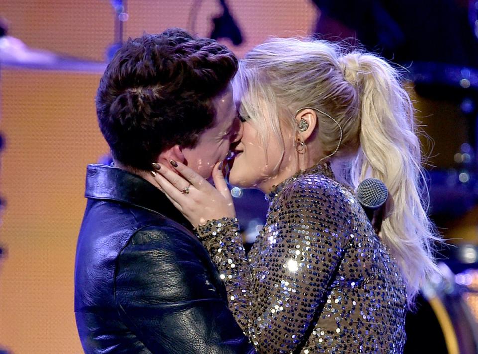 Charlie Puth and Meghan Trainor kiss onstage at the 2015 American Music Awards (Getty Images)