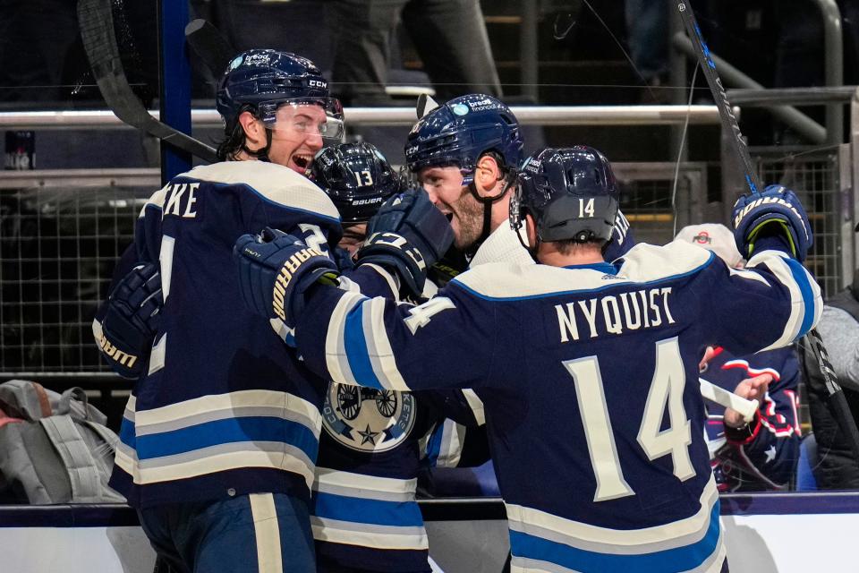 Oct 18, 2022; Columbus, Ohio, USA;  Columbus Blue Jackets celebrate with forward Johnny Gaudreau (13) after he scored a game tying goal during the third period between the Columbus Blue Jackets and the Vancouver Canucks at Nationwide Arena. Mandatory Credit: Joseph Scheller-The Columbus Dispatch