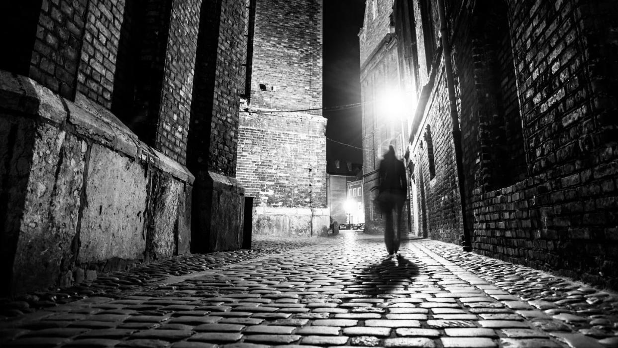 illuminated cobbled street in old city by night