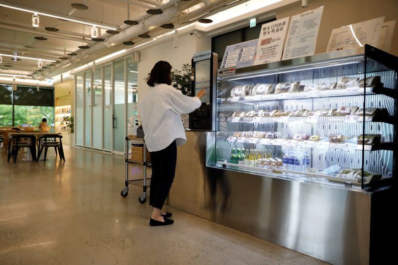 A customer orders a coffee at a cafe where a robot that takes orders, makes coffee and brings the drinks straight to customers is being used in Daejeon