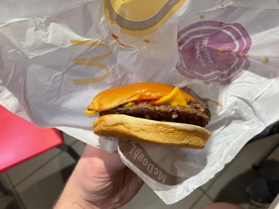 hand holding up a mcdonalds double cheeseburger