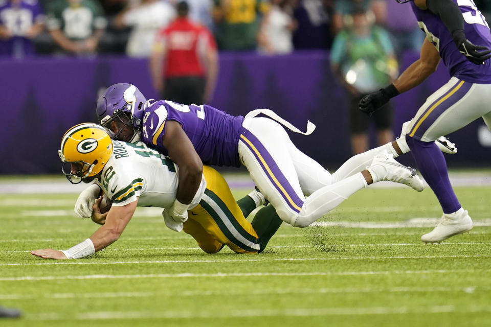 Green Bay Packers quarterback Aaron Rodgers, left, is sacked by Minnesota Vikings linebacker D.J. Wonnum during the second half of an NFL football game, Sunday, Sept. 11, 2022, in Minneapolis. (AP Photo/Abbie Parr)