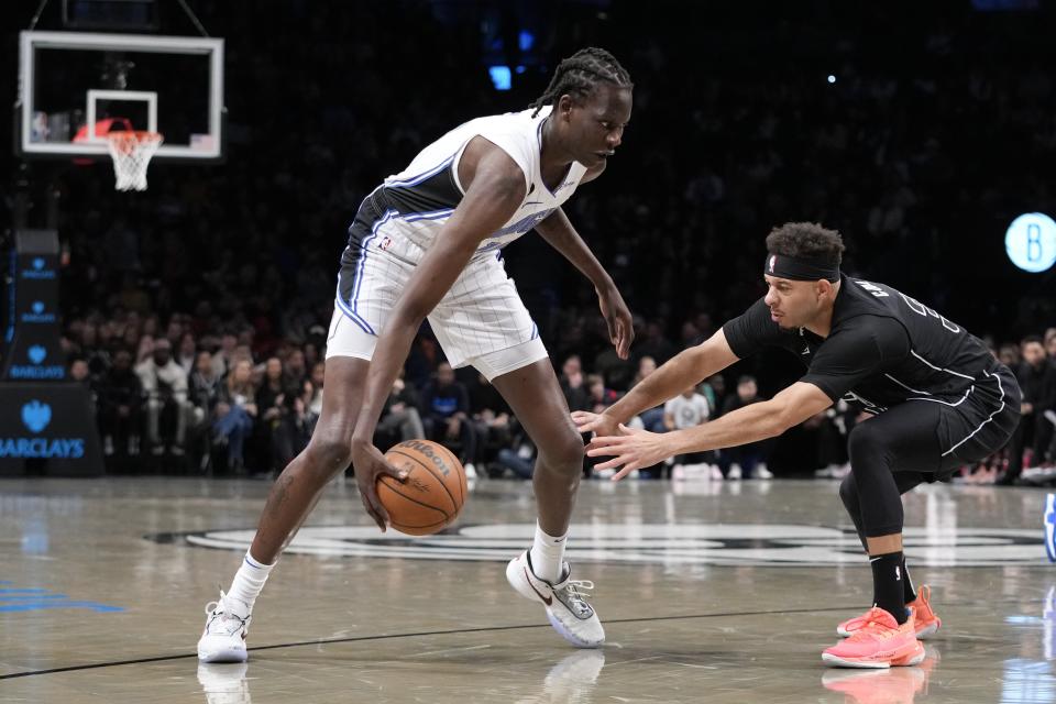 Orlando Magic center Bol Bol, left, drives against Brooklyn Nets guard Seth Curry during the first half of an NBA basketball game Friday, April 7, 2023, in New York. (AP Photo/Mary Altaffer)