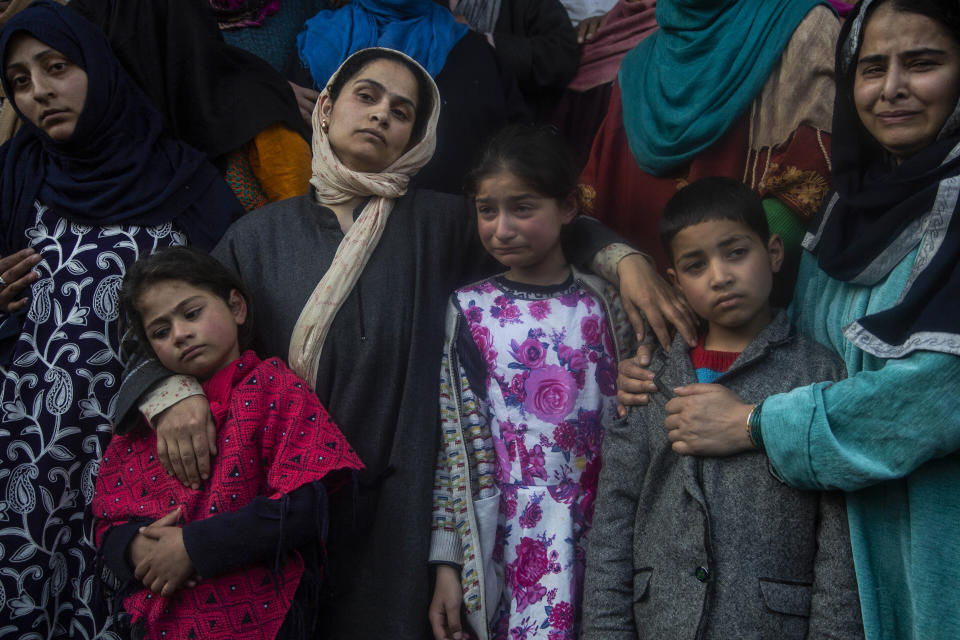 Wife and children wail near the coffin of elected official Riyaz Ahmad during his funeral in Sopore, 55 kilometers (34 miles) north of Srinagar, Indian controlled Kashmir, Monday, March. 29, 2021. Gunmen killed an elected official of India's ruling party and a policeman in disputed Kashmir on Monday, police said. Police blamed anti-India militants for the attack. None of the rebel groups that have been fighting against Indian rule since 1989 immediately claimed responsibility for the attack. (AP Photo/Mukhtar Khan).