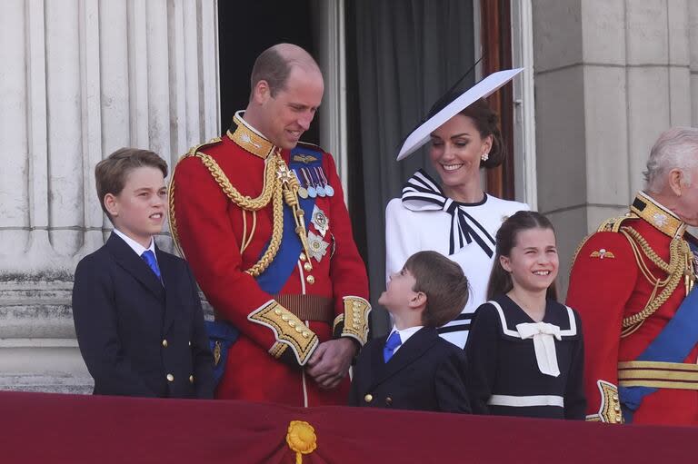 El príncipe Luis habla con sus padres, Guillermo y Kate, en el balcón del Palacio de Buckingham