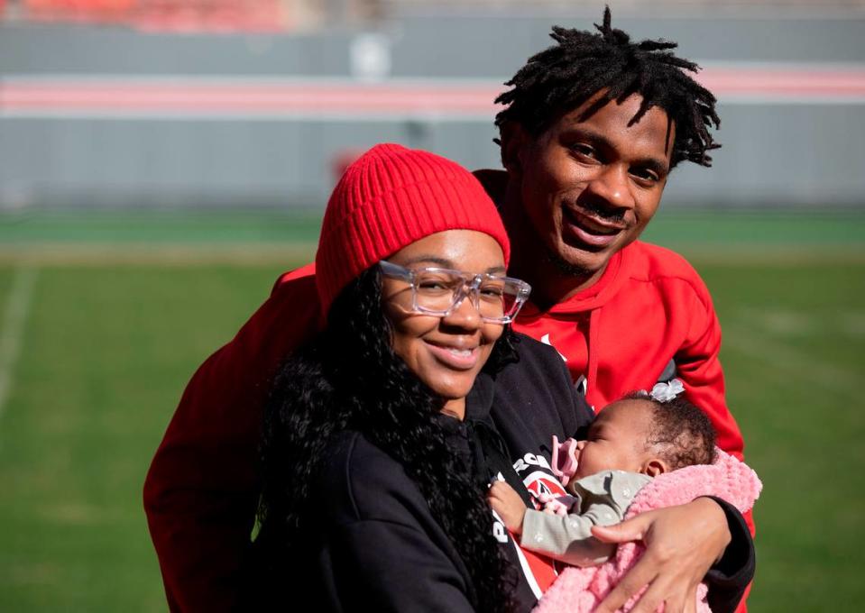 N.C. State’s Rakeim Ashford and Asia Owens stand with their three-month-old daughter, Ra’Kiya, on the field at Carter-Finley Stadium on Tuesday, Nov. 14, 2023, in Raleigh, N.C.