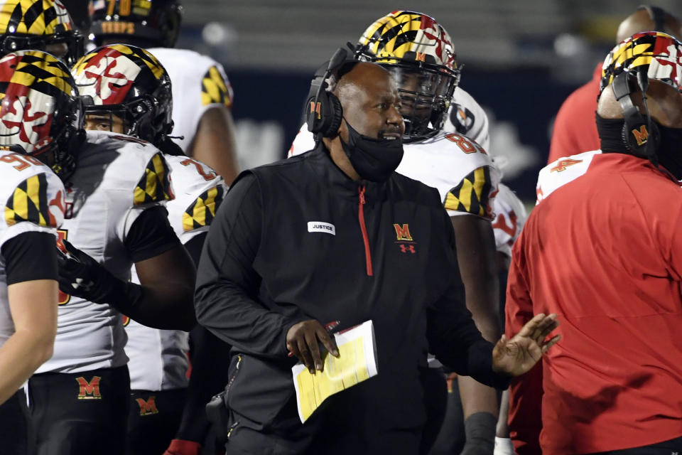 FILE - In this Saturday, Nov. 7, 2020, file photo, Maryland head coach Mike Locksley, center, talks with his players during a timeout late in the fourth quarter of an NCAA college football game against Penn State in State College, Pa. An outbreak of COVID-19 on the Maryland football team that resulted in a positive test for head coach Michael Locksley has caused the cancellation of Saturday’s Big Ten game against Michigan State. (AP Photo/Barry Reeger, File)