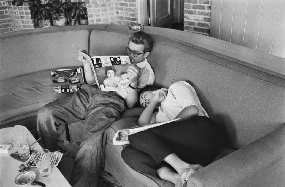 <p>Dean and Taylor are photographed relaxing while on the set of <em>Giant</em>. If you look closely, you can see Taylor on the cover of the magazine Dean is reading.  </p>