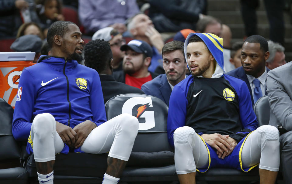 Golden State Warriors forward Kevin Durant, left, talks with guard Stephen Curry, right, during the second half of an NBA basketball game against the Chicago Bulls, Monday, Oct. 29, 2018, in Chicago. (AP Photo/Kamil Krzaczynski)