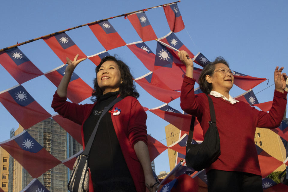 In this photo taken Thursday, Jan. 9, 2020, supporters of the Nationalist or KMT party pose with the Taiwanese flag during a rally for the presidential election in Taipei, Taiwan. About two-thirds of Taiwanese don't identify as Chinese, according to a survey released Tuesday, highlighting the challenge China faces to bringing the self-governing island under its control. The U.S.-based Pew Research Center found that 66 percent view themselves as Taiwanese, 28 percent as both Taiwanese and Chinese and 4 percent as just Chinese. (AP Photo/Ng Han Guan)