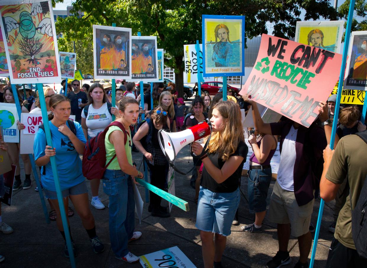 Marina Moyce, 17, from South Eugene High School, center, joins other students from across Eugene at a rally at the Wayne Morse Free Speech Plaza in Eugene as part of a protest to end the era of fossil fuels.