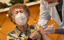 FILE - A resident of a nursing home reacts as she gets an injection of the COVID-19 vaccine in Cologne, Germany,, Dec. 27, 2020. The first shipments of coronavirus vaccines developed by BioNTech and Pfizer have arrived across the European Union, authorities started to vaccinate the most vulnerable people in a coordinated effort on Sunday. Germany is set to mark 100,000 deaths from COVID-19 this week, passing a somber milestone that several of its neighbors crossed months ago but which some in Western Europe's most populous nation had hoped to avoid. (AP Photo/Martin Meissner)