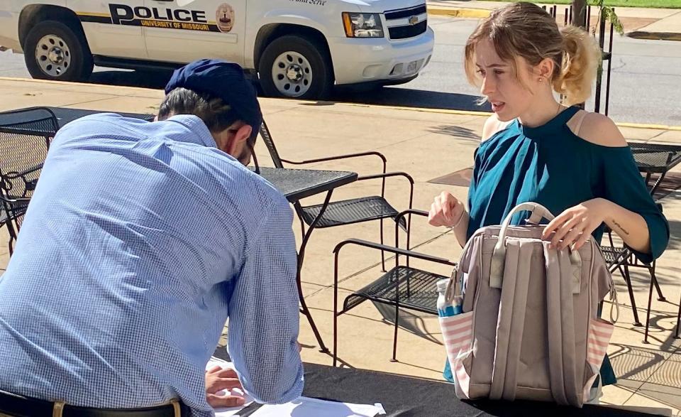 Gabriela Ionita, an MU biological sciences student from Romania, picks up supplies from Harjeev Singh, founder of Helping Hands, a not-for-profit organization.