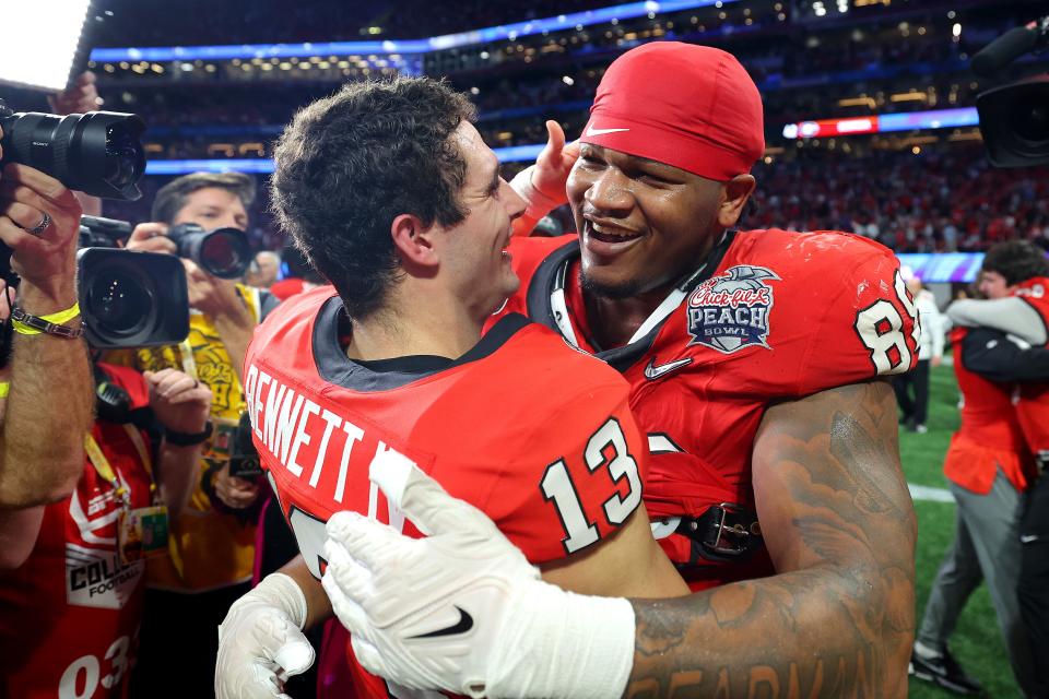 Stetson Bennett #13 and Jalen Carter #88 of the Georgia Bulldogs celebrate after defeating the Ohio State Buckeyes in the Chick-fil-A Peach Bowl at Mercedes-Benz Stadium on December 31, 2022 in Atlanta, Georgia (Getty Images)