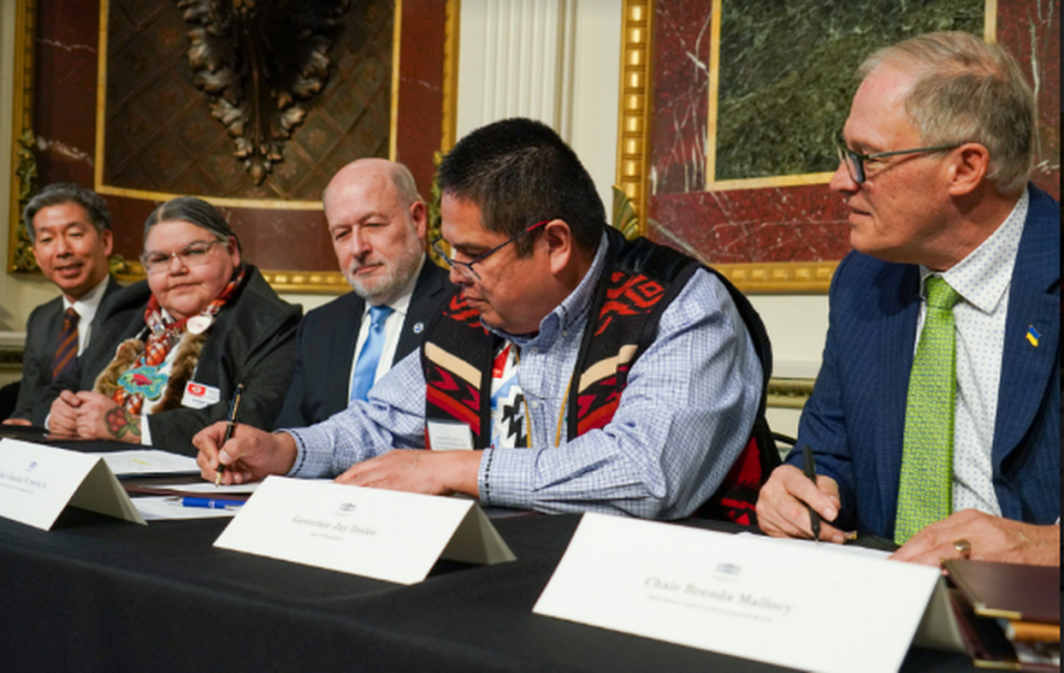 Washington Gov. Jay Inslee, right, watches as Chairman Jonathan Smith of the Confederate Tribes of Warm Springs signs the Columbia River Basin restoration agreement at the White House. Office of Gov. Jay Inslee
