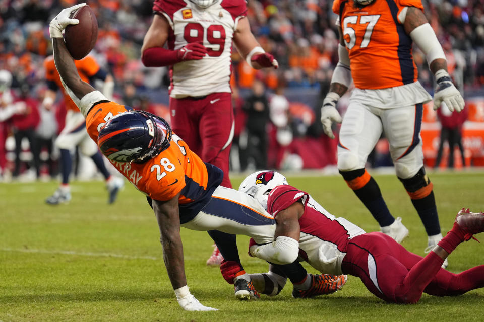 Denver Broncos running back Latavius Murray (28) stretches for a touchdown as Arizona Cardinals safety Budda Baker defends during the second half of an NFL football game, Sunday, Dec. 18, 2022, in Denver. (AP Photo/Jack Dempsey)
