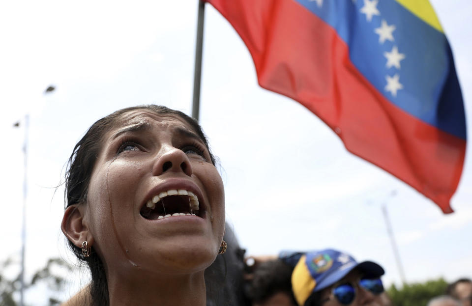 Venezuelan migrant Yanela Aleman cries as she sings her national anthem in La Parada, near Cucuta, Colombia, on the border with Venezuela, Sunday, Feb. 17, 2019. As part of U.S. humanitarian aid to Venezuela, Sen. Marco Rubio, R-Fla is visiting the area where the medical supplies, medicine and food aid is stored before it it expected to be taken across the border on Feb. 23. (AP Photo/Fernando Vergara)