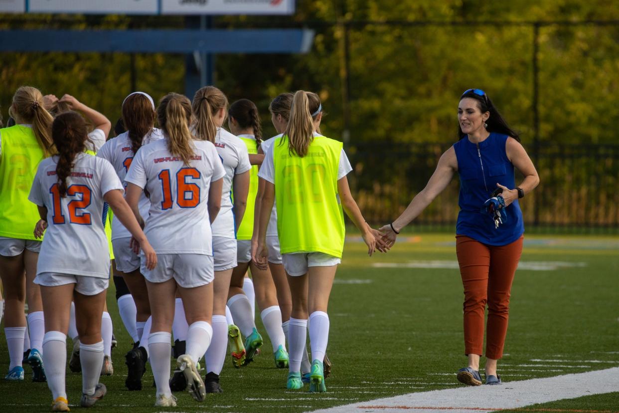 UW-Platteville athletic director Kristina Navarro-Krupka high-fives players on the university's soccer team in 2021. Navarro-Krupka died over the weekend.