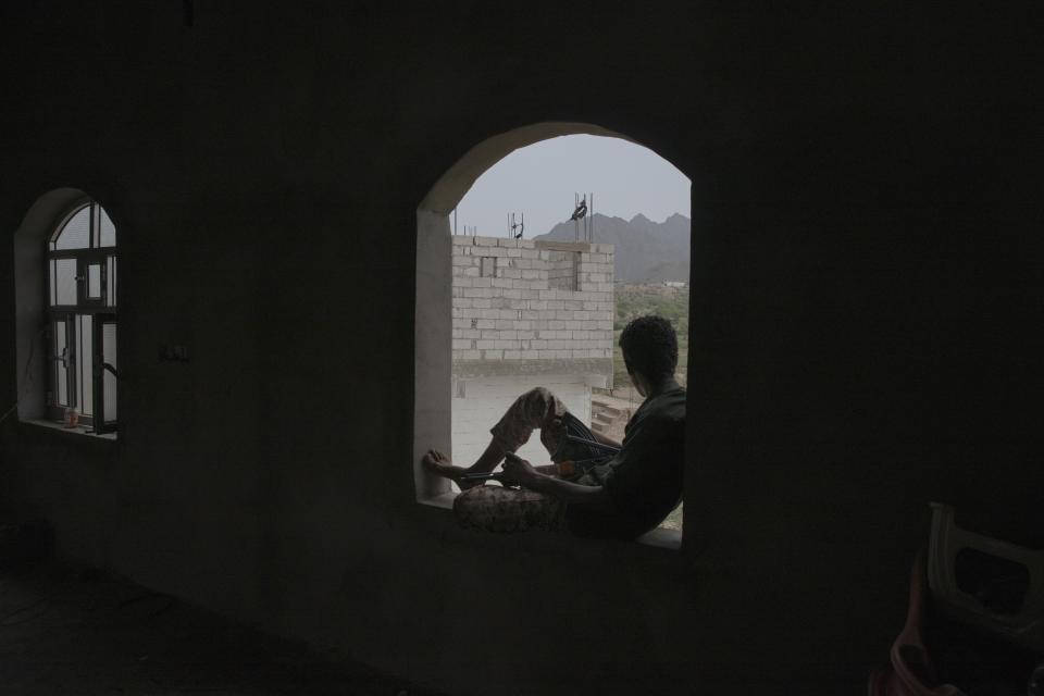 In this Monday, Aug. 5, 2019 photo, a fighter from a militia known as the Security Belt, that is funded and armed by the United Arab Emirates, takes shelter near the Gabhet Hajr frontline with Houthi rebels, in Yemen's Dhale province. Yemen’s civil war has been deadlocked for months, with neither side making major gains. At one of the most active front lines, militiamen backed by the Saudi-led coalition are dug in, exchanging shelling every night with Iranian-allied Houthi rebels only a few hundred meters away. (AP Photo/Nariman El-Mofty)