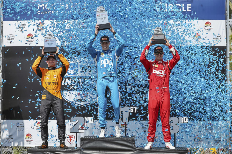 FILE - Team Penske driver Josef Newgarden, center, celebrates his first place finish along with second place finisher Arrow McLaren driver Pato O'Ward of Mexico, left, and third place finisher Team Penske driver Scott McLaughlin of New Zealand in the IndyCar Grand Prix of St. Petersburg auto race, Sunday, March 10, 2024, in St. Petersburg, Fla. Team Penske suffered a humiliating disqualification Wednesday, April 24, when reigning Indianapolis 500 winner Josef Newgarden was stripped of his victory in the season-opening race for manipulating his push-to-pass system. Penske teammate Scott McLaughlin, who finished third in the opener on the downtown streets of St. Petersburg, Florida, was also disqualified. (AP Photo/Mike Carlson, File)