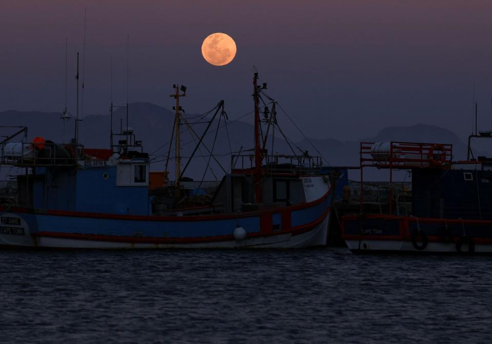 A super moon, known as the Blue Moon, rises over Kalk Bay harbour in Cape Town. 