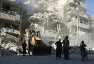 A tractor clears the rubble following airstrikes by the Syrian regime in the rebel held neighbourhood of Tariq a-Bab in Aleppo on September 24, 2016