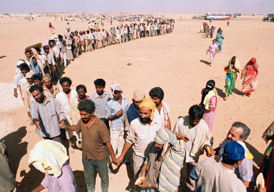 Refugees from Iraq's invasion of Kuwait line up for bread at Ruweishid, Jordan, Sept. 3, 1990. 