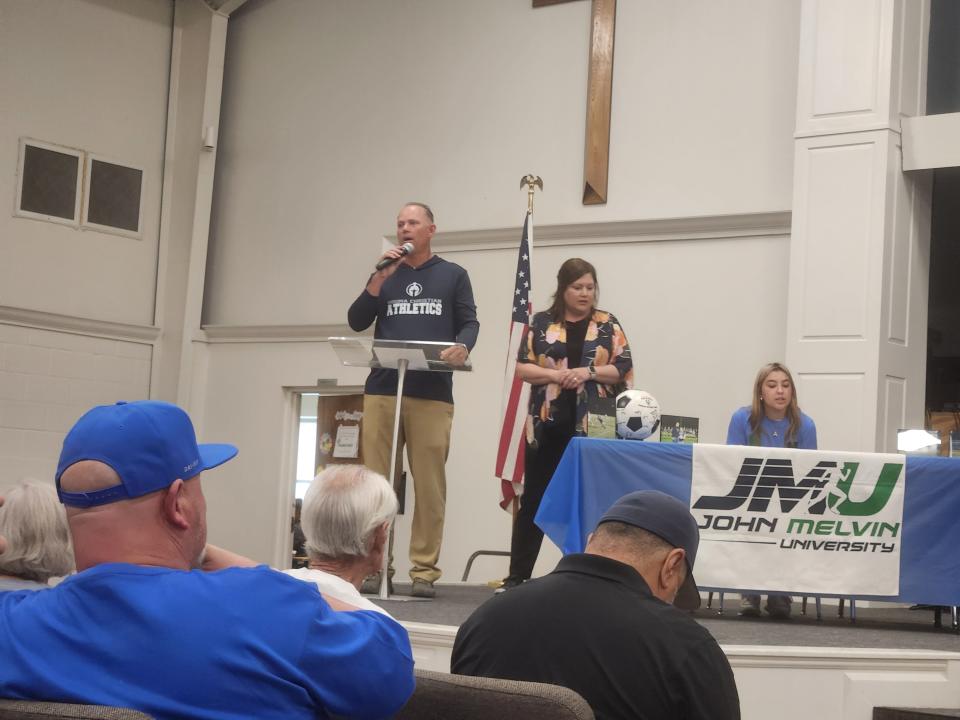 Houma Christian School Athletic Director Chuck Battaglia opens Thursday's autograph session with a prayer.