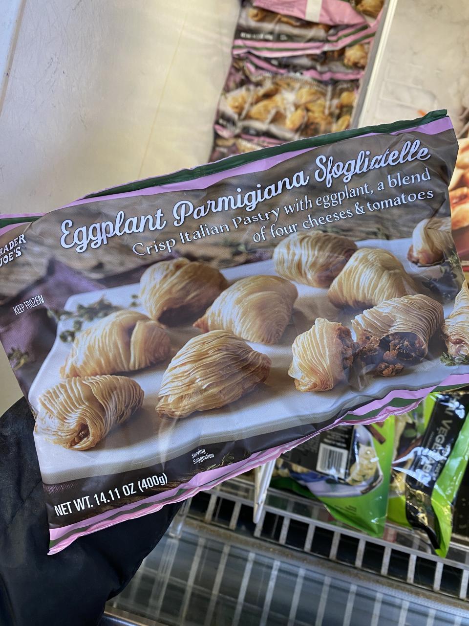 hand holding a bag of eggplant parmigiana sfogliatelle 