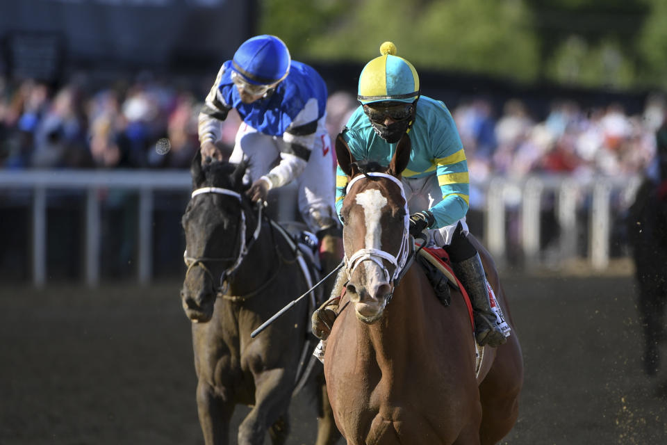 Joel Rosario, right, atop Army Wife crosses the finish line ahead of Ricardo Santana Jr. atop Willful Woman to win the Black-Eyed Susan Stakes horse race at Pimlico Race Course, Friday, May 14, 2021, in Baltimore. (AP Photo/Will Newton)