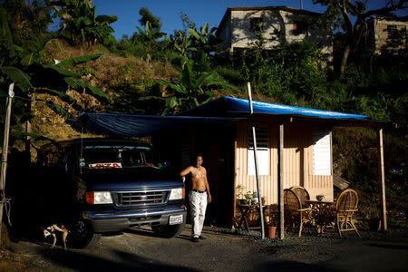 Jorge Salgado poses for a picture next to a house he built with parts of his house, which was destroyed by Hurricane Maria, at the squatter community of Villa Hugo in Canovanas, Puerto Rico, December 12, 2017. REUTERS/Carlos Garcia Rawlins