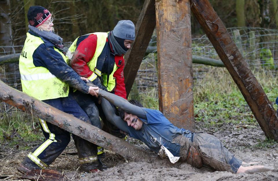 Competitor is dragged out of the mud during the Tough Guy event in Perton