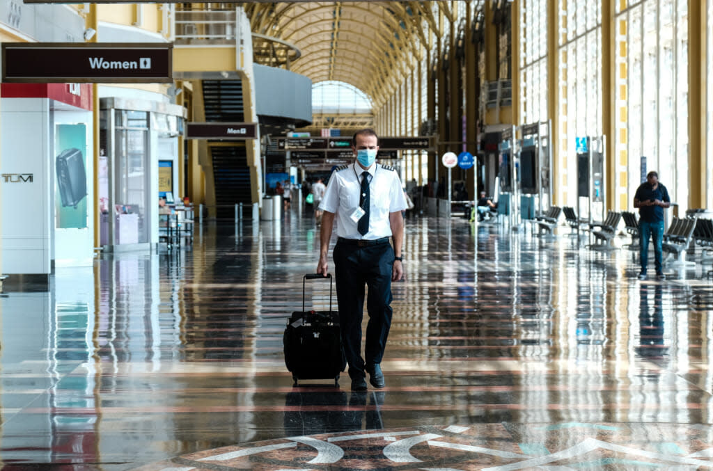 A pilot walks through the terminal at the Ronald Reagan National Airport on July 22, 2020 in Arlington, Virginia. (Photo by Michael A. McCoy/Getty Images)