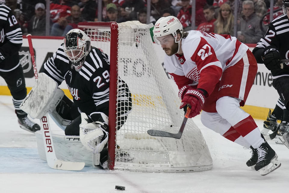 Detroit Red Wings' Michael Rasmussen, right, brings the puck around in front of New Jersey Devils goaltender Mackenzie Blackwood during the second period of an NHL hockey game in Newark, N.J., Friday, April 29, 2022. (AP Photo/Seth Wenig)