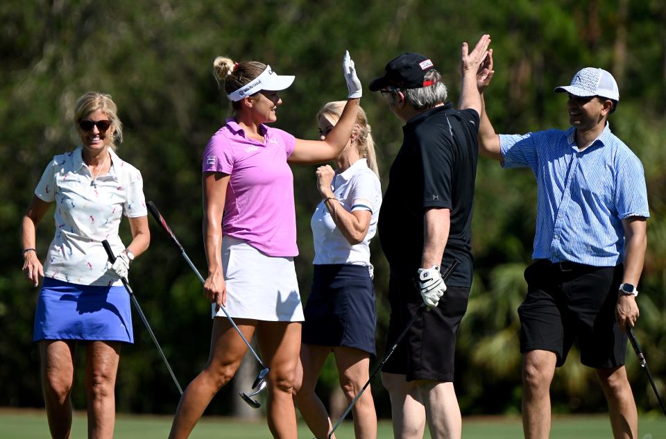 Lexi Thompson high fives everyone after a putt on the 7th green during the 2022 CME Group Tour Golf Championship Pro-Am.