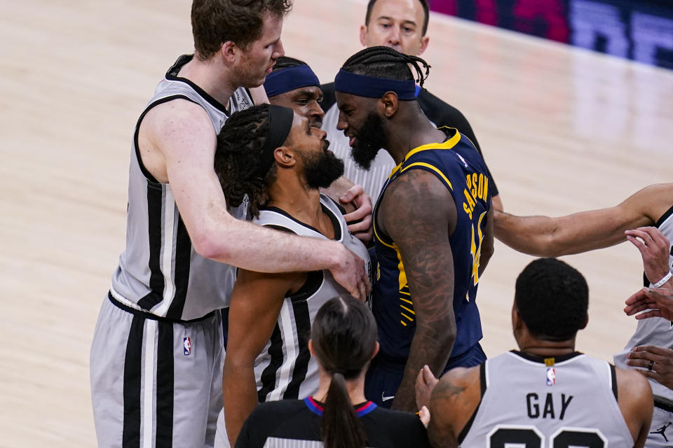 Indiana Pacers forward JaKarr Sampson (14) and San Antonio Spurs guard Patty Mills (8) exchange words during the second half of an NBA basketball game in Indianapolis, Monday, April 19, 2021. (AP Photo/Michael Conroy)