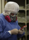 A health worker covered un full protective gear against the spread of the new coronavirus chats on her mobile phone inside the COVID-19 ward of the Mexico City Ajusco Medio General Hospital, Wednesday, Dec. 2. 2020. Mexico continues to report an increase in the number of coronavirus cases, with Mexico City continuing to report the biggest portion of the surge. (AP Photo/Marco Ugarte)