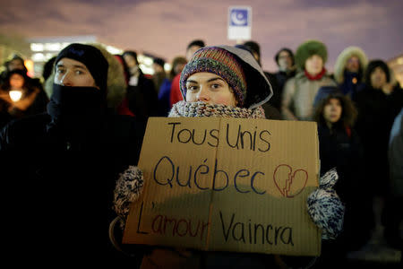 A woman holds a sign reading "everyone united / love will conquer" as people attend a vigil in support of the Muslim community in Montreal, Quebec, January 30, 2017. REUTERS/Dario Ayala