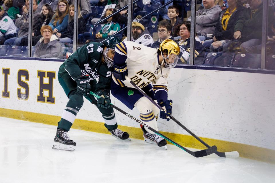 Notre Dame defenseman Ben Brinkman (2) and Michigan State forward Jagger Joshua (23) battle along the boards during the Michigan State-Notre Dame NCAA hockey game on Sunday, March 05, 2023, at Compton Family Ice Arena in South Bend, Indiana.