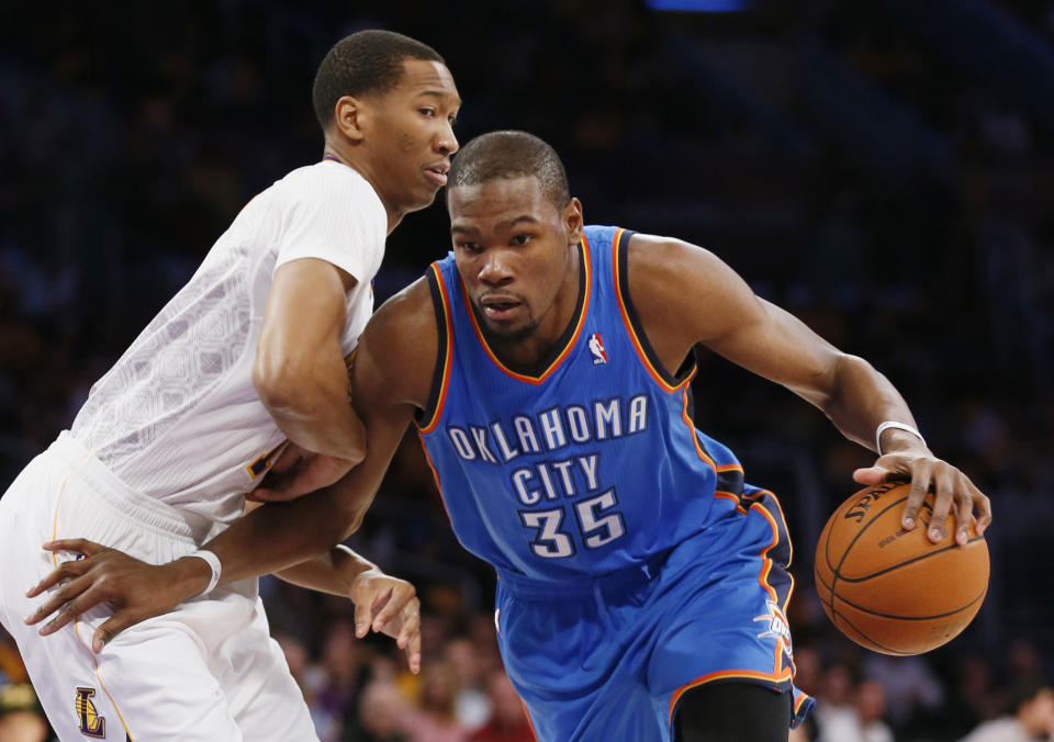 Oklahoma City Thunder small forward Kevin Durant, right, drives with the ball as Los Angeles Lakers small forward Wesley Johnson defends agaisnt him during the first half of an NBA basketball game in Los Angeles, Sunday, March 9, 2014. (AP Photo/Danny Moloshok)