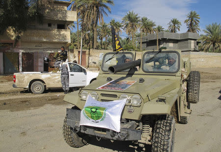 Members of the Iraqi security forces and Shiite fighters take part in an intensive security deployment after taking control of Saadiya in Diyala province from Islamist State militants, November 24, 2014. REUTERS/Stringer