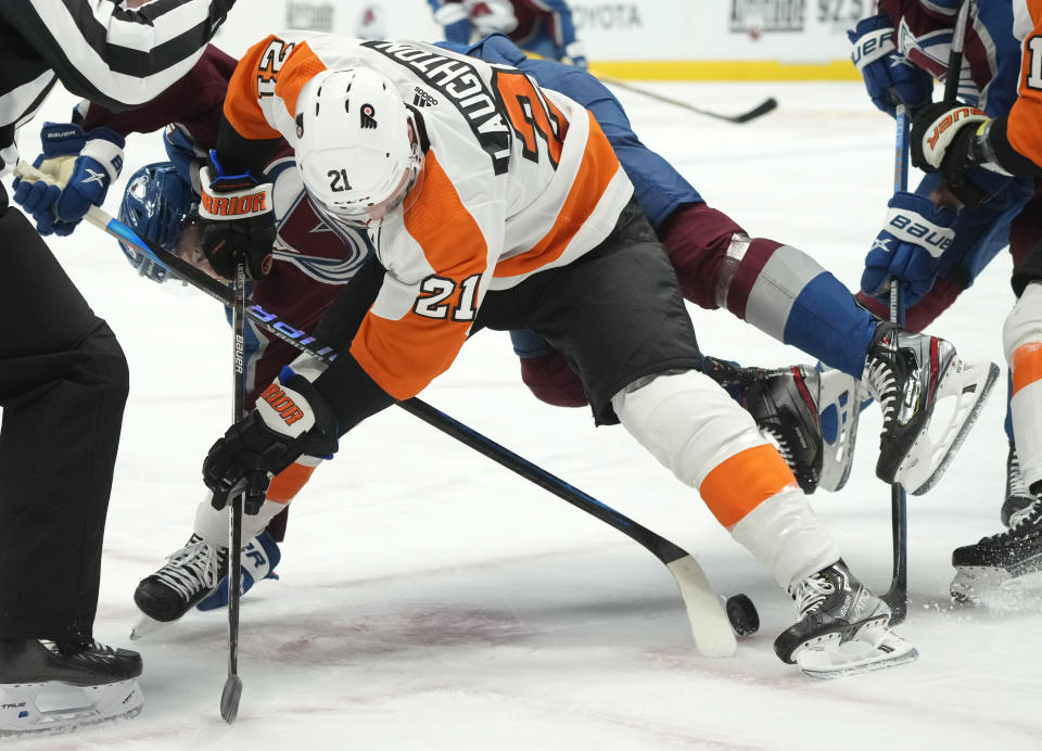 Philadelphia Flyers center Scott Laughton, front, fights for control of the puck with Colorado Avalanche left wing J.T. Compher in the first period of an NHL hockey game Tuesday, Dec. 13, 2022, in Denver. (AP Photo/David Zalubowski)